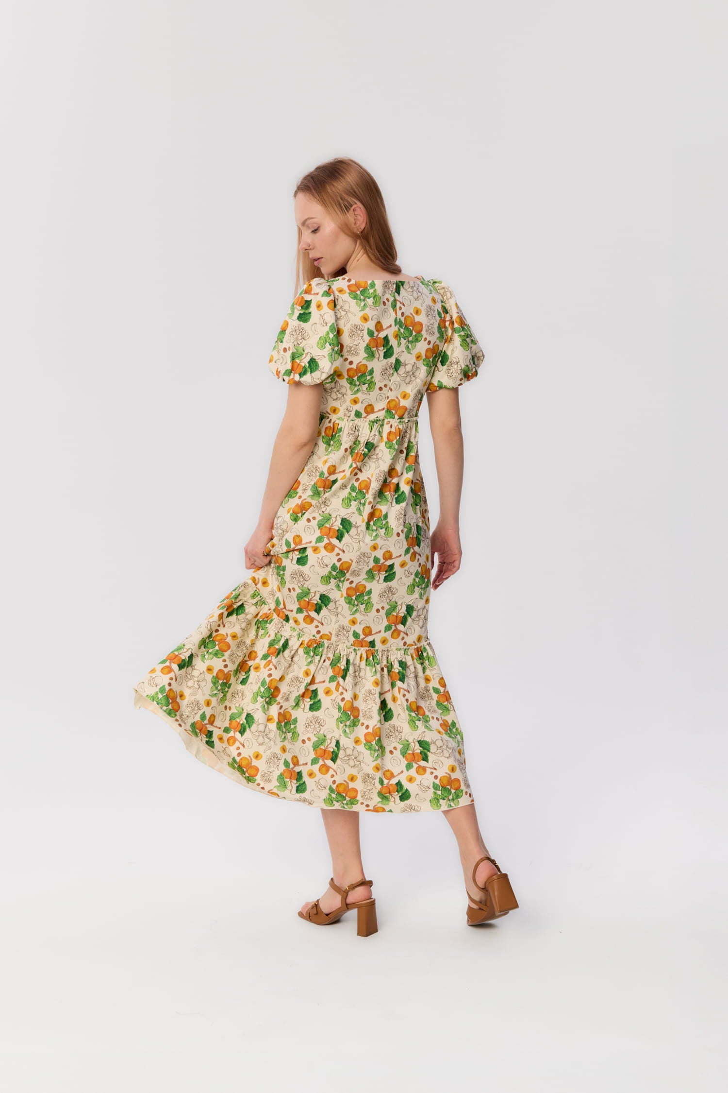 Modelka w sukience maxi Berti z bufiastymi rękawami i printem moreli, widok z tyłu, letnia stylizacja w ruchu.