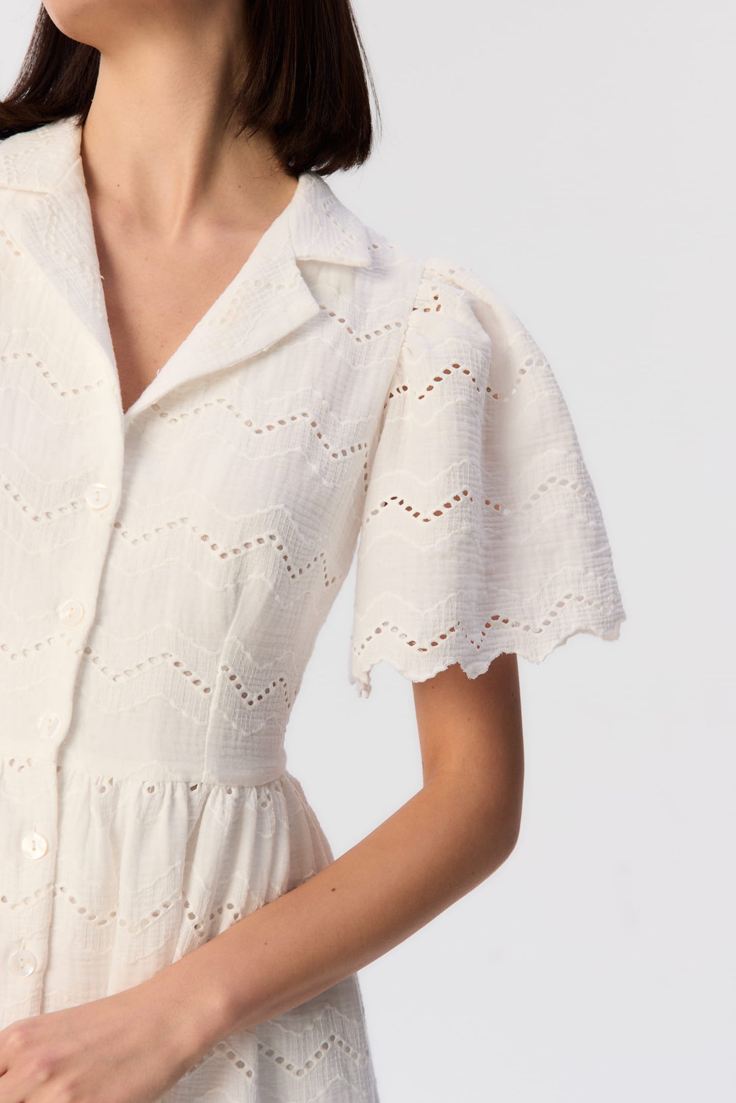 Zbliżenie na detal sukienki Duttonka MAG NOLLY – haftowany muślin, kołnierzyk i bufiaste rękawy z falowanym wykończeniem.