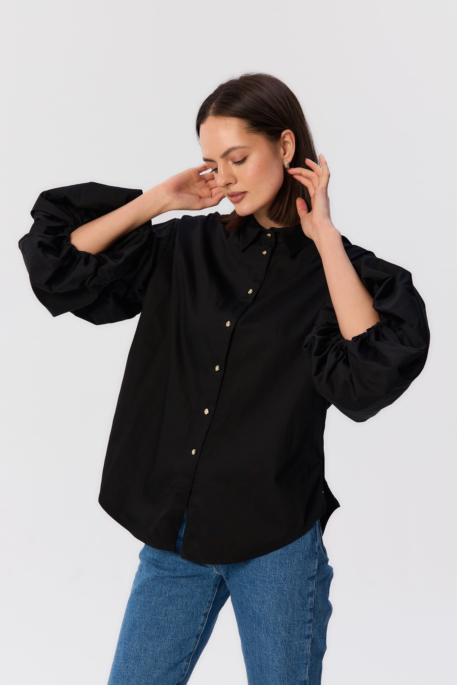 Zbliżenie na czarną koszulę Lisi MAG NOLLY z bufiastymi rękawami i złotymi guziczkami w kształcie róży, widok z przodu.