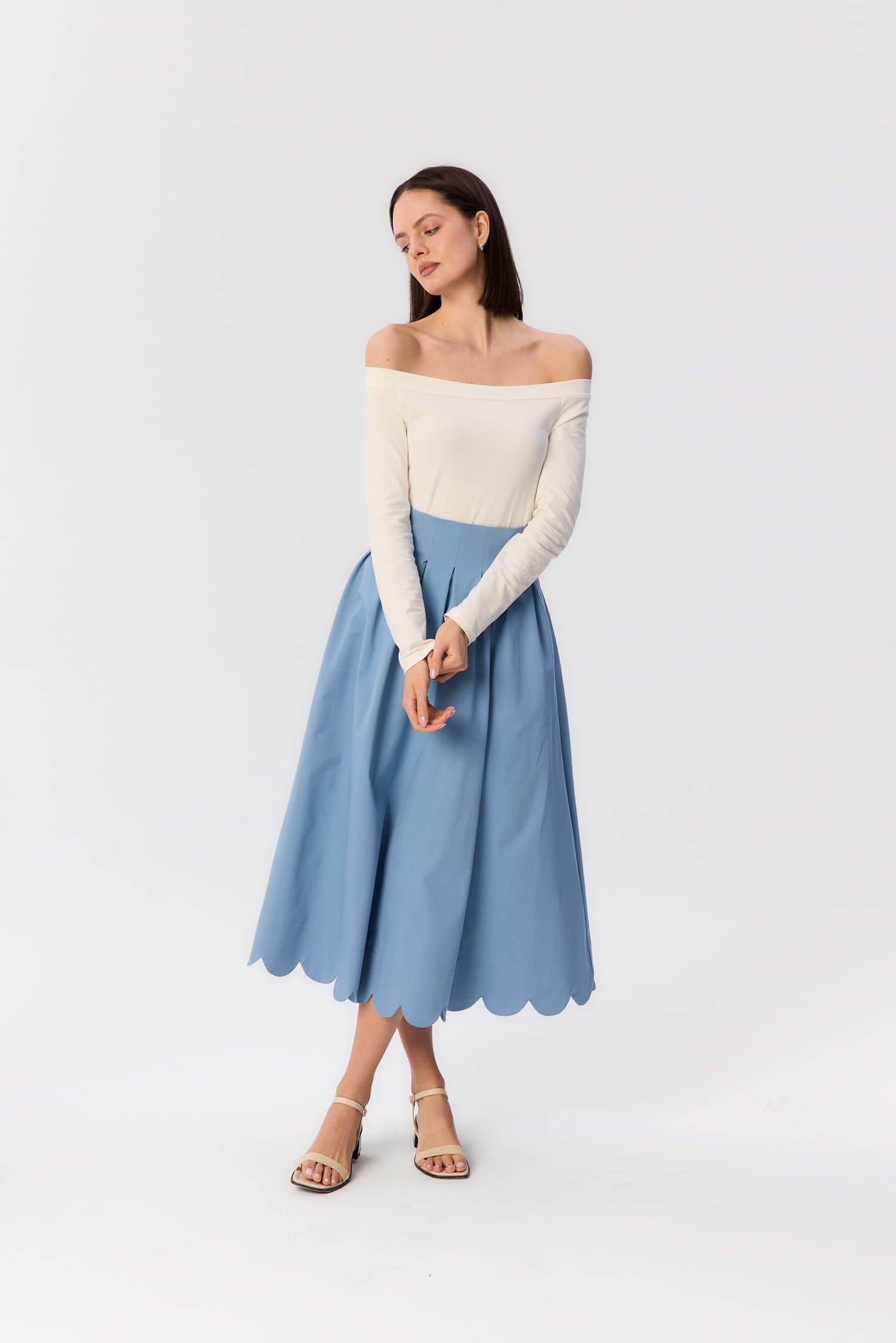 Longsleeve Mori od MAG NOLLY – kremowy top z certyfikowanej bawełny z dekoltem odsłaniającym ramiona, w zestawie ze spódnicą midi.