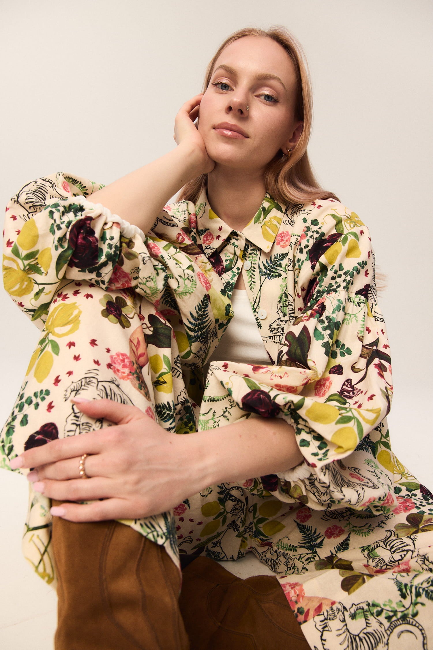 Modelka w zestawie MAG NOLLY: koszula Lisi i spodnie Cardinale we wzór Abstrakcja – siedząca poza w zbliżeniu.