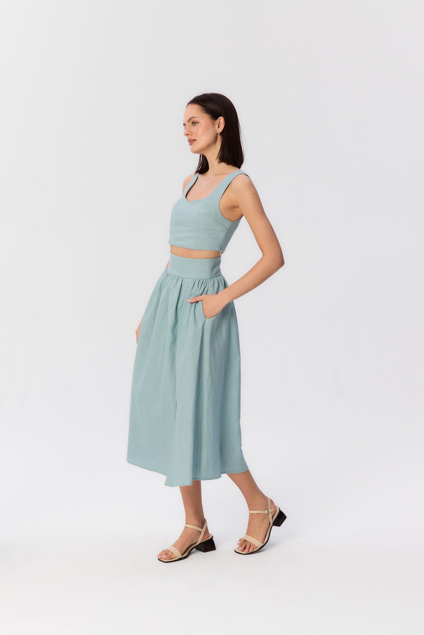 Modelka w turkusowym komplecie – top Milo i spódnica Sandrelli midi z wysokim stanem i kieszeniami.