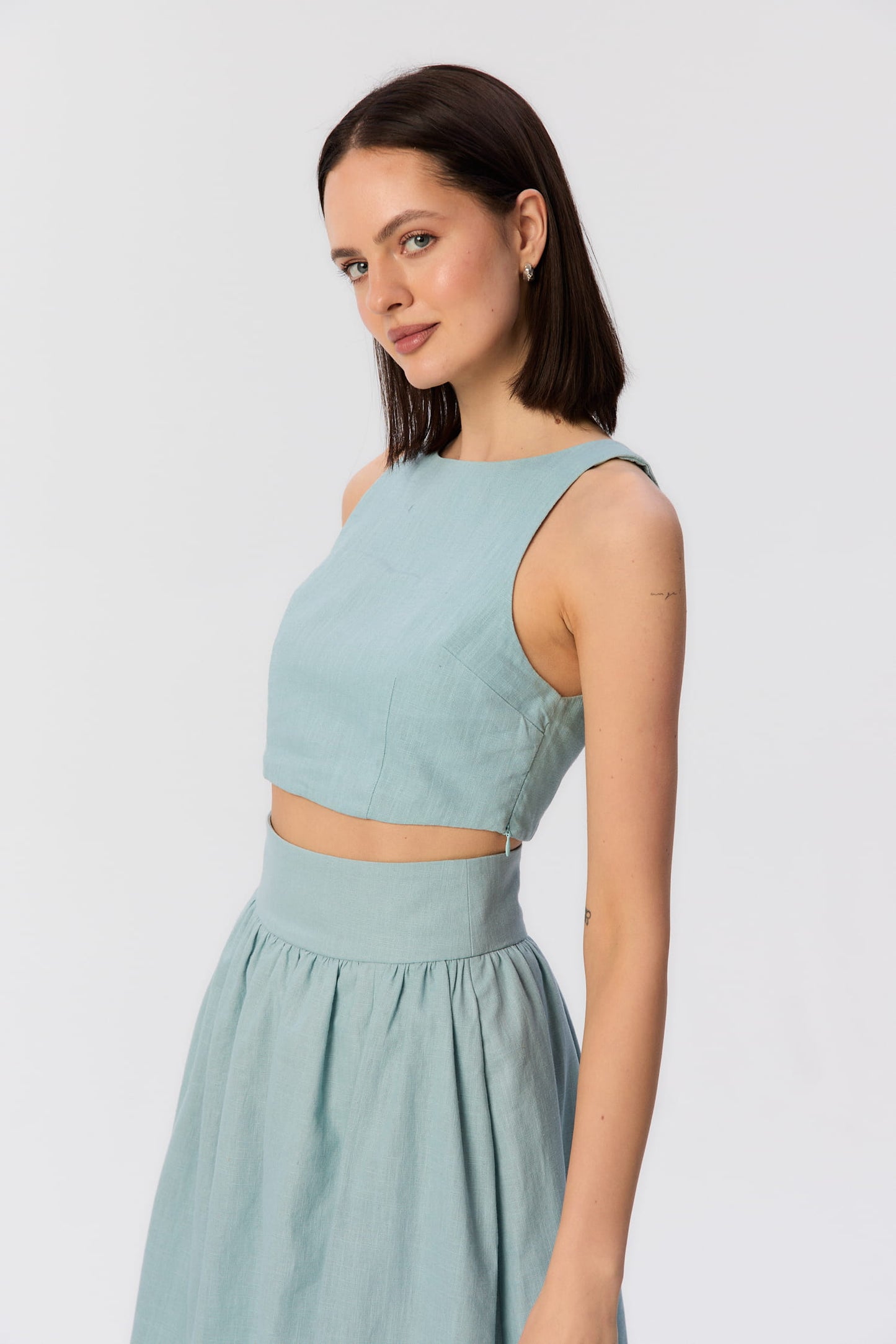 Modelka w turkusowym topie Loren i spódnicy Sandrelli, widok z boku, stylizacja letnia z kolekcji lookbook