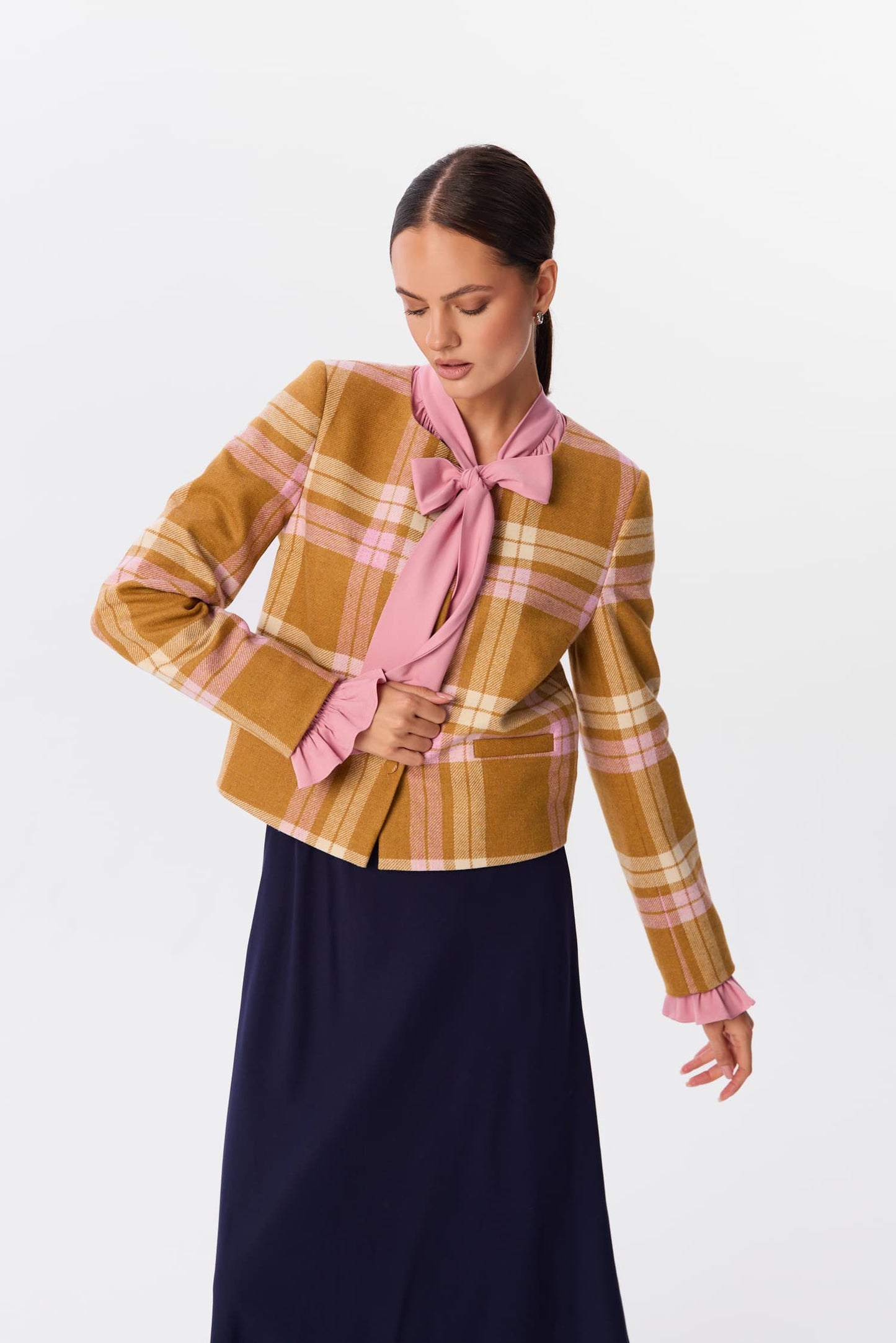 Żakiet Serina w kratę Candle Plaid w odcieniach ochry i różu, ujęcie półprofilowe z modelem żakietu zawiązanego na kokardę – MAG NOLLY