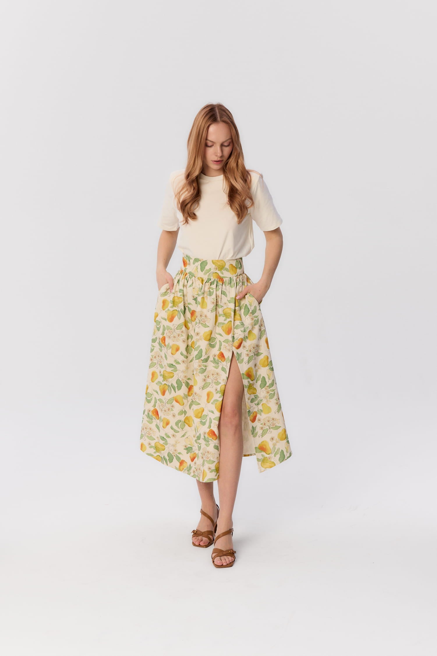 Modelka w spódnicy midi Sandrelli MAG NOLLY w autorski wzór gruszek, z wysokim stanem i rozcięciem z boku.