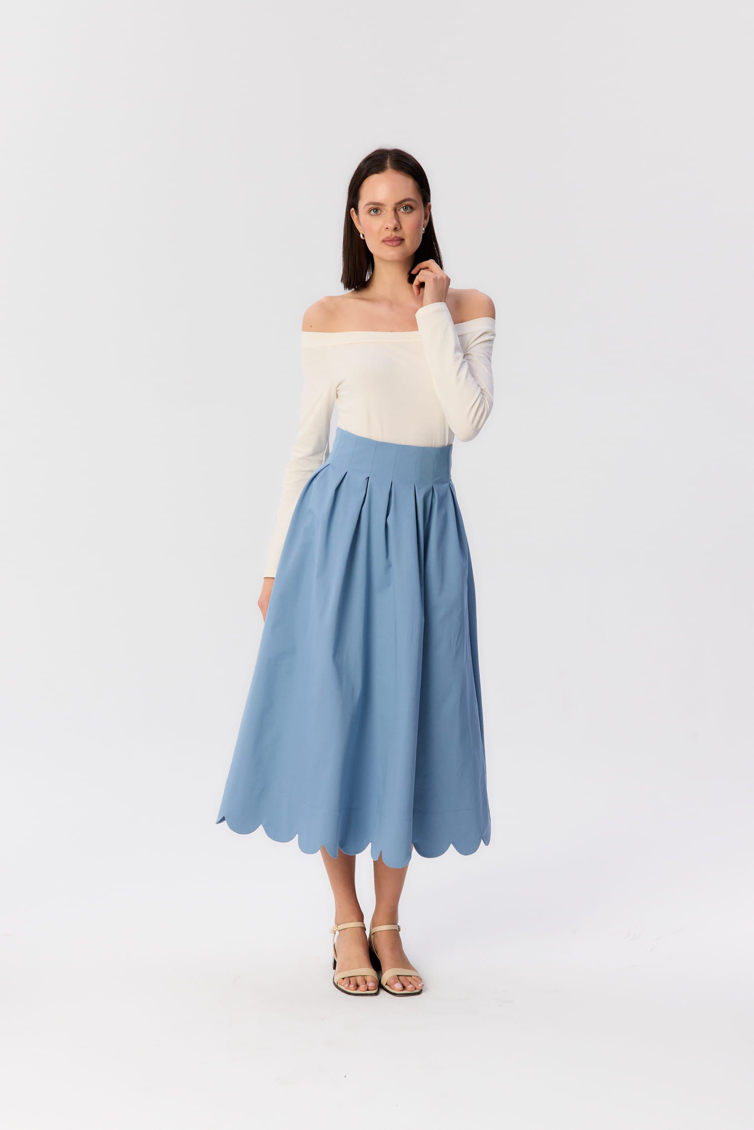 Modelka w niebieskiej spódnicy Fala od MAG NOLLY – fason midi z falowanym dołem, podkreśloną talią i eleganckim, kobiecym krojem.