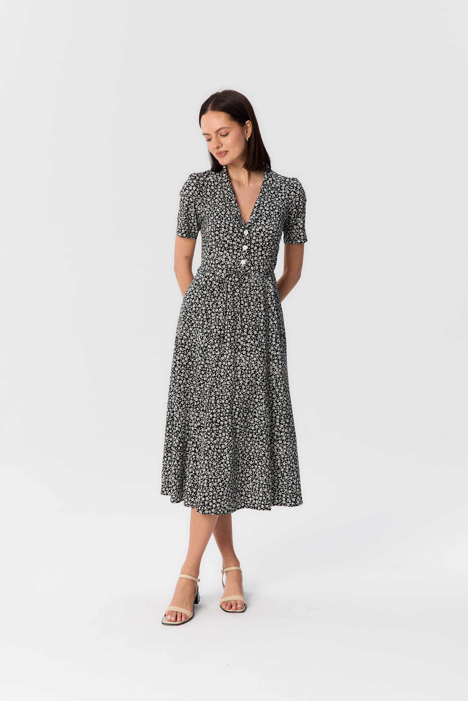 Modelka w czarno-białej sukience midi Bellucci z wiskozy, z krótkim rękawem, kołnierzykiem i drobnym kwiatowym wzorem, projekt MAG NOLLY.