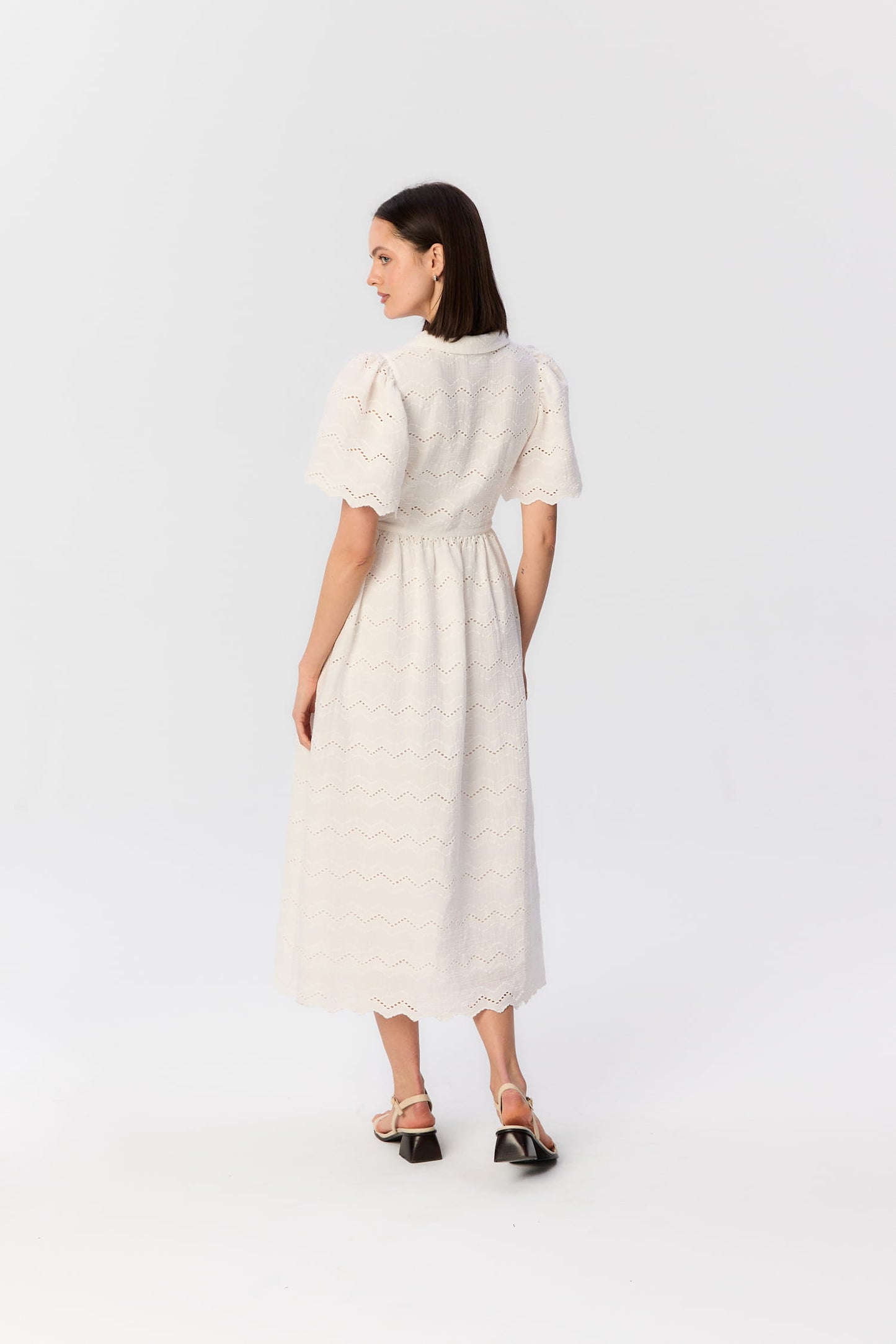 Tył sukienki Duttonka z haftowanego muślinu – biała midi z bufkami i lekko zaznaczoną talią, projekt MAG NOLLY w letniej odsłonie.