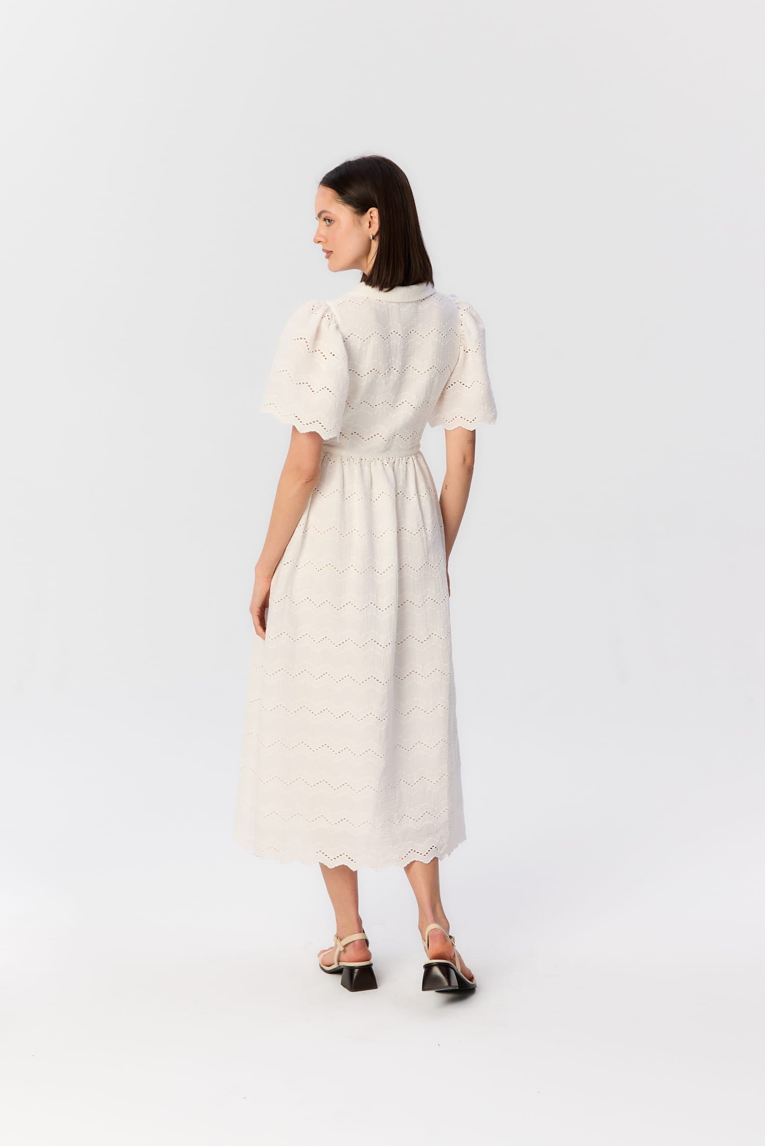 Tył sukienki Duttonka z haftowanego muślinu – biała midi z bufkami i lekko zaznaczoną talią, projekt MAG NOLLY w letniej odsłonie.