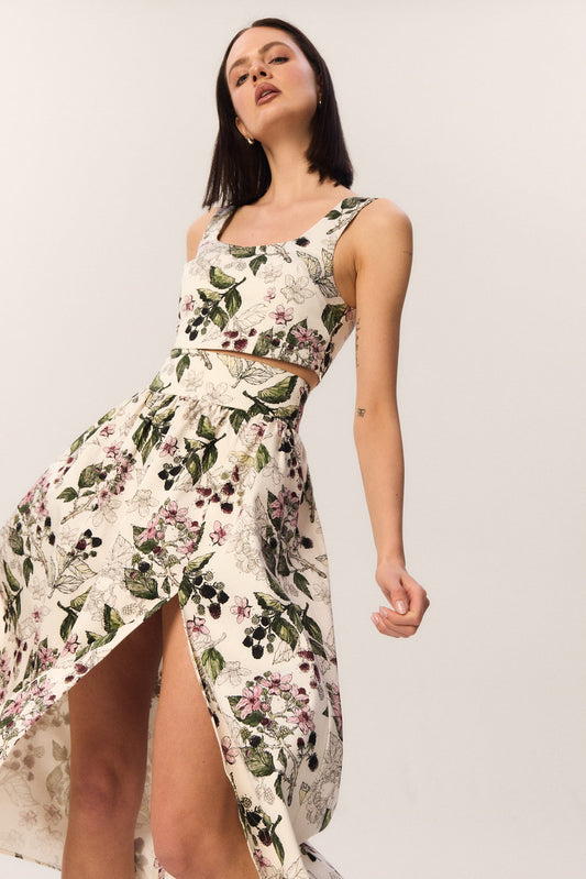 Modelka w topie Milo i spódnicy midi Sandrelli w autorski wzór jeżyn, dynamiczne ujęcie z rozcięciem eksponującym nogę.