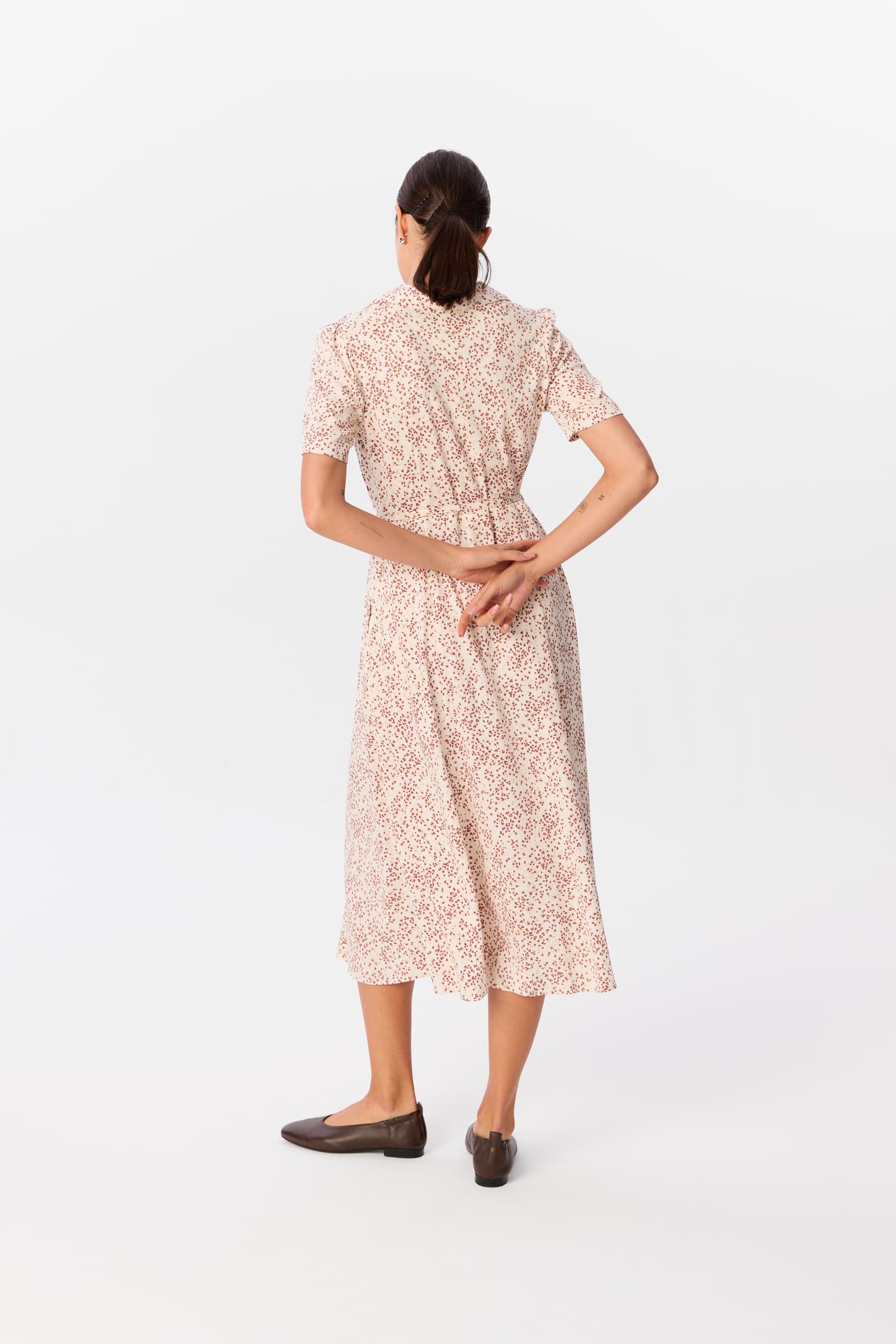 Sukienka Bellucci Rosella, midi w jasny print w drobne plamki, widok z tyłu – modelka z rękami splecionymi za plecami – MAG NOLLY