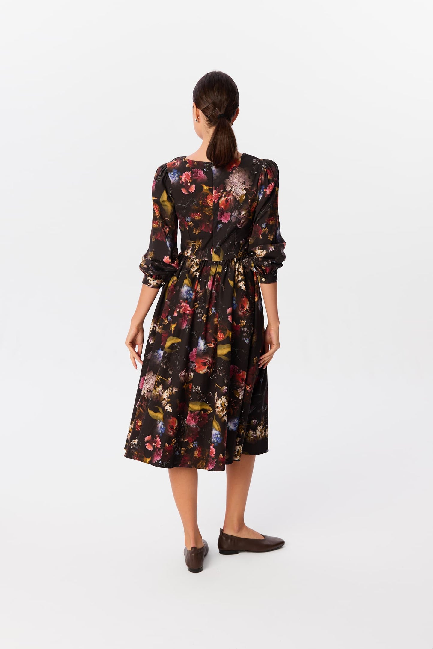 Sukienka Leone w print Kolaż, widok z tyłu – czarna midi z rozkloszowanym dołem i marszczonymi rękawami, modelka na białym tle – MAG NOLLY