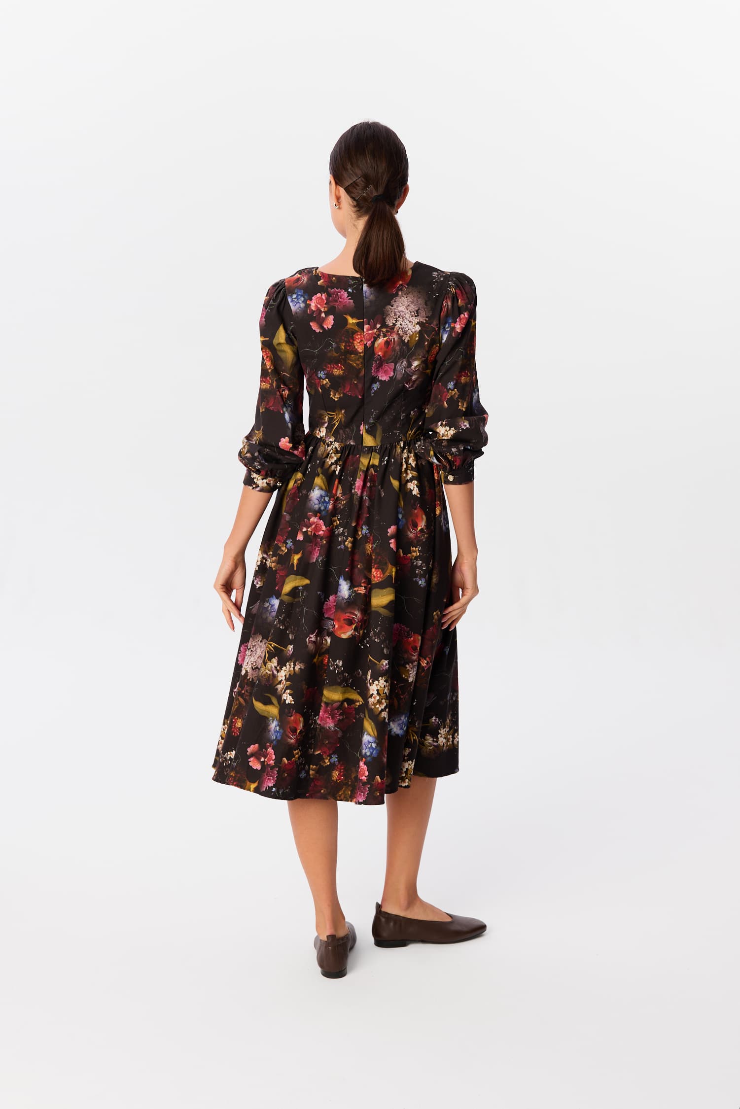 Sukienka Leone w print Kolaż, widok z tyłu – czarna midi z rozkloszowanym dołem i marszczonymi rękawami, modelka na białym tle – MAG NOLLY