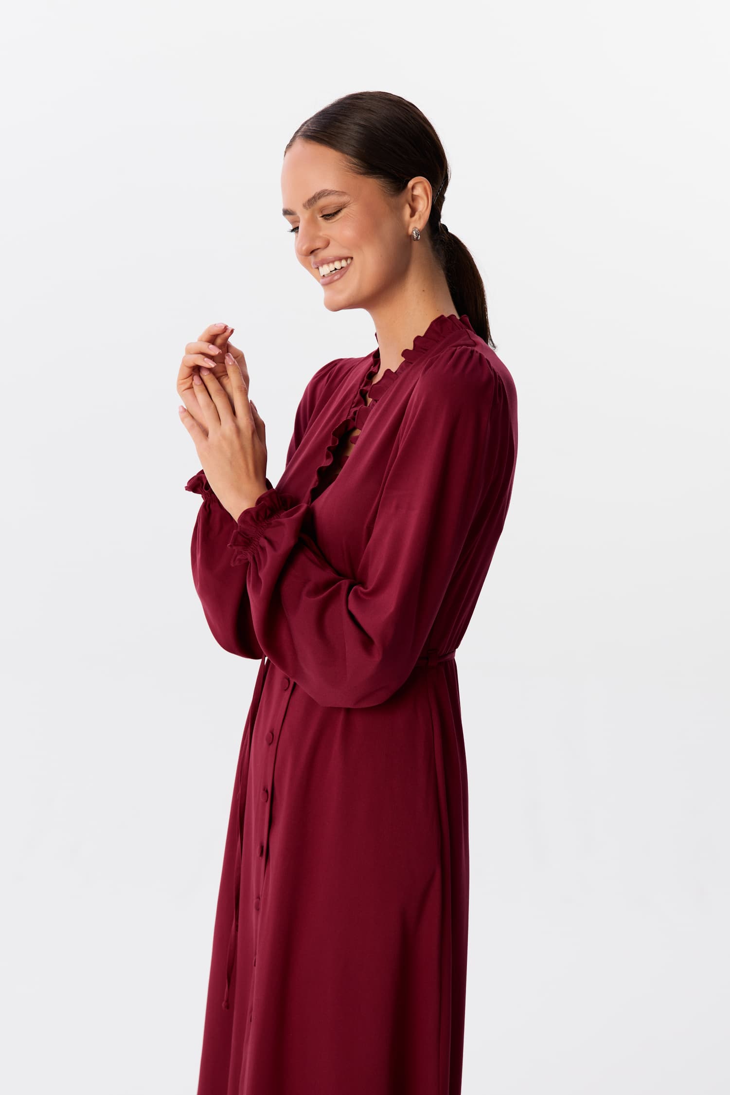 Sukienka midi Velata w kolorze Bordeaux, ujęcie półprofil z uśmiechniętą modelką – MAG NOLLY