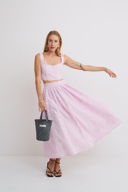 Spódnica Belle Mag Nolly – lilaróż, rozkloszowana spódnica midi w ruchu, haft kwiatowy, komplet z topem Milo, uśmiechnięta modelka
