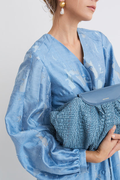 Sukienka Roma Mag Nolly – Blue Dust, zbliżenie na dekolt V, bufiaste rękawy, połysk i faktura tkaniny z abstrakcyjnym wzorem